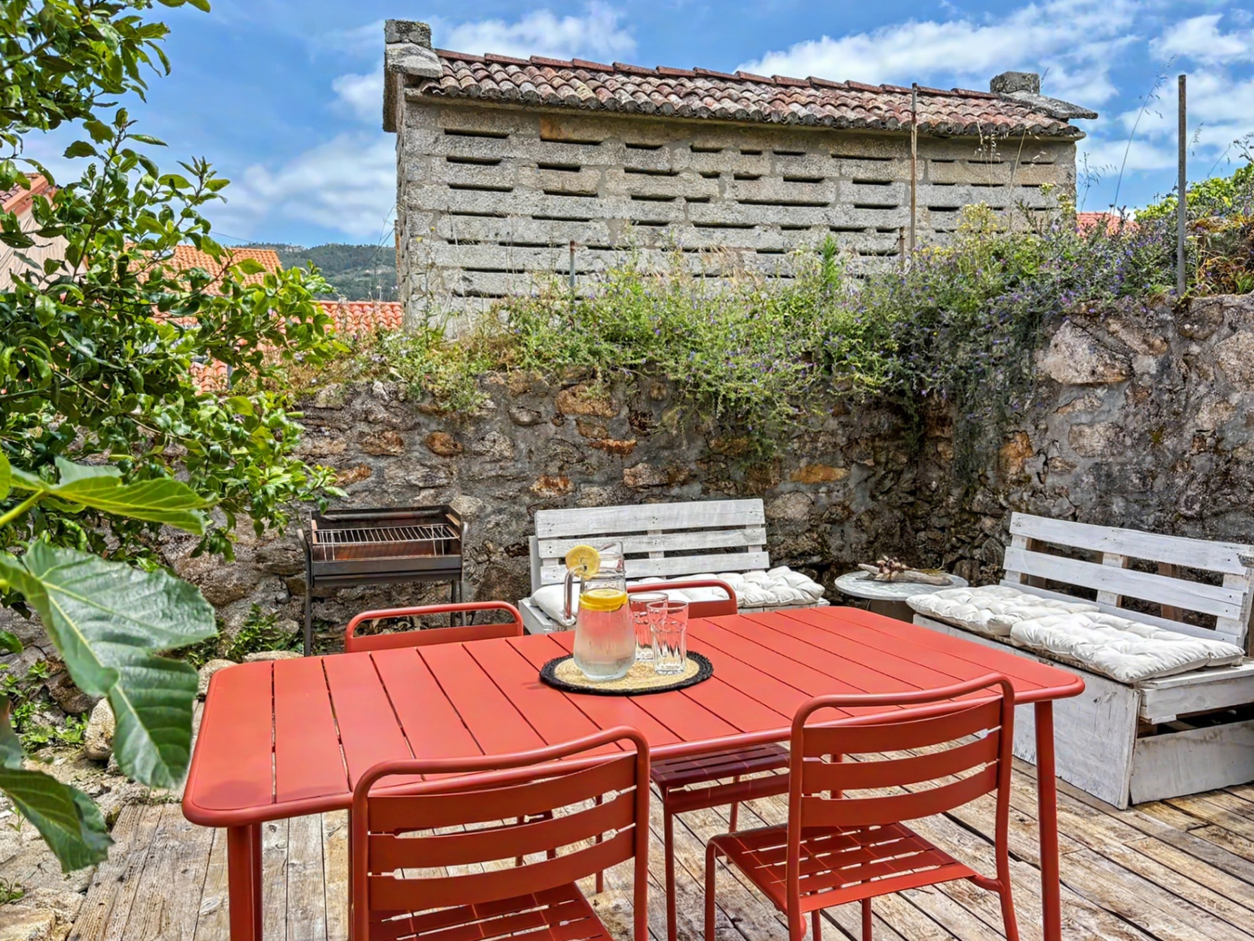 Sunny terrace with red table and Galician hórreo